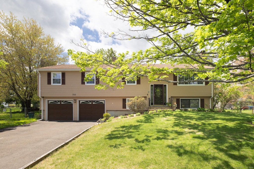 bi-level home with an attached garage and asphalt driveway
