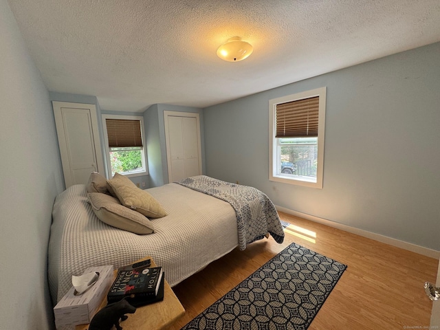 17 Green Rd, Vernon, CT 06066 - bedroom featuring multiple windows, a textured ceiling, wood finished floors, baseboards, and a closet