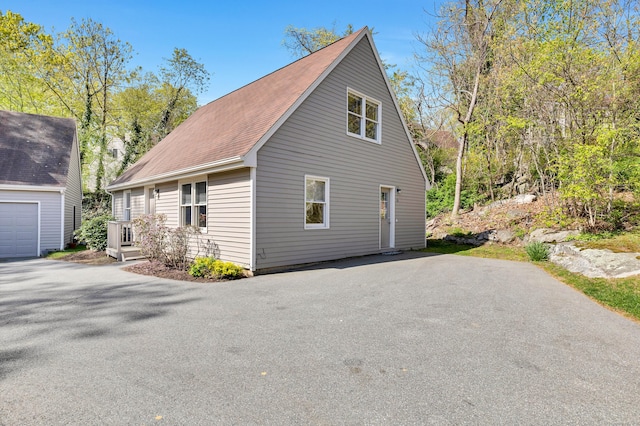 16 Copper Hill Dr Unit 16, Guilford, CT 06437 - view of side of home with a shingled roof and driveway