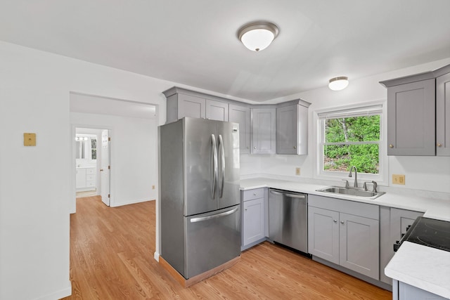 16 Copper Hill Dr Unit 16, Guilford, CT 06437 - kitchen with light countertops, gray cabinets, a sink, light wood finished floors, and appliances with stainless steel finishes