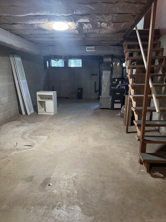 below grade area featuring heating unit and stairs