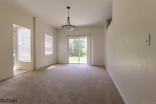 carpeted spare room featuring baseboards