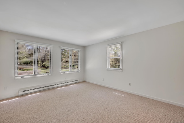 carpeted spare room with baseboards and a baseboard heating unit