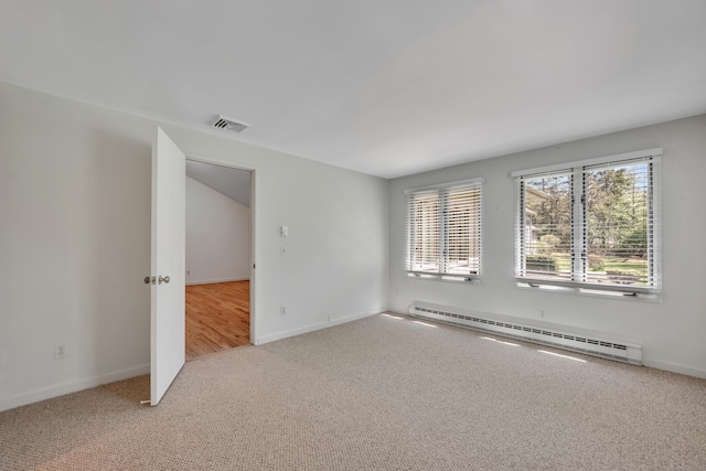 carpeted empty room featuring baseboards, visible vents, and baseboard heating