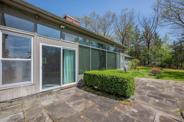view of property exterior with a patio, a yard, and a chimney
