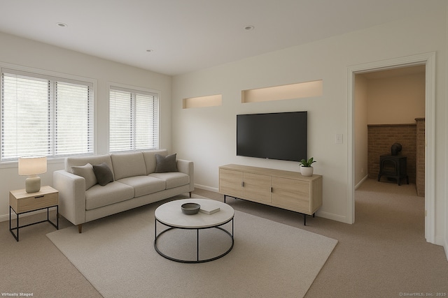 living area featuring baseboards, light colored carpet, and a wood stove
