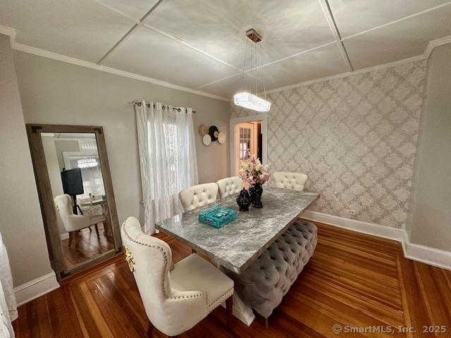 dining room with baseboards, ornamental molding, dark wood finished floors, and wallpapered walls