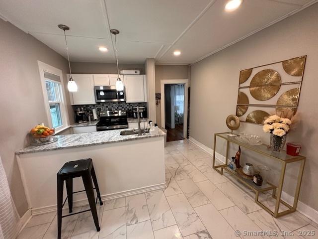 kitchen featuring a sink, appliances with stainless steel finishes, recessed lighting, and marble finish floor