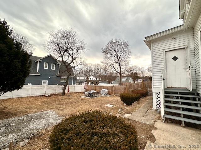 view of yard featuring entry steps and fence