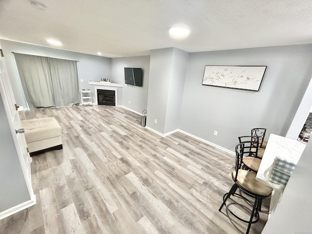 3409 Whitney Ave Apt 24, Hamden, CT 06518 - living area with light wood finished floors, baseboards, and a fireplace