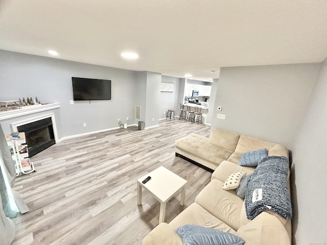 3409 Whitney Ave Apt 24, Hamden, CT 06518 - living area with light wood-style flooring, a fireplace, recessed lighting, and baseboards