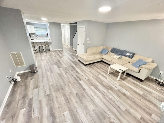 3409 Whitney Ave Apt 24, Hamden, CT 06518 - living room with light wood-type flooring, baseboards, and stairway