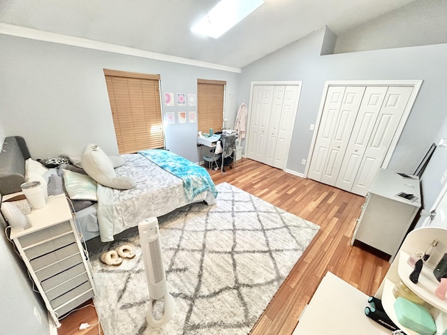 3409 Whitney Ave Apt 24, Hamden, CT 06518 - bedroom featuring lofted ceiling, two closets, light wood-type flooring, and baseboards