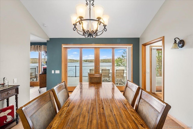 dining room with a notable chandelier, a healthy amount of sunlight, and lofted ceiling