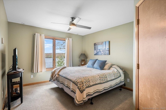 carpeted bedroom featuring baseboards and a ceiling fan