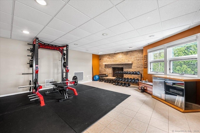 exercise area featuring visible vents, a fireplace, a drop ceiling, recessed lighting, and tile patterned floors