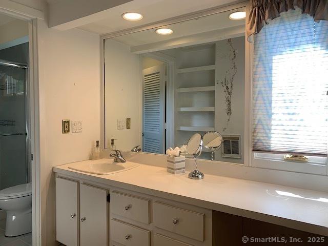 full bath with an enclosed shower, toilet, recessed lighting, and vanity