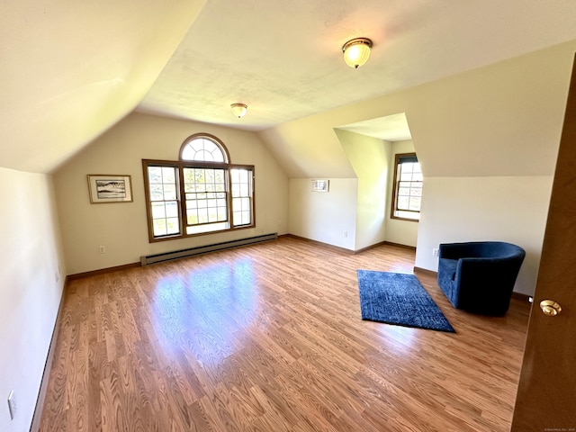 additional living space with baseboards, wood finished floors, baseboard heating, and vaulted ceiling