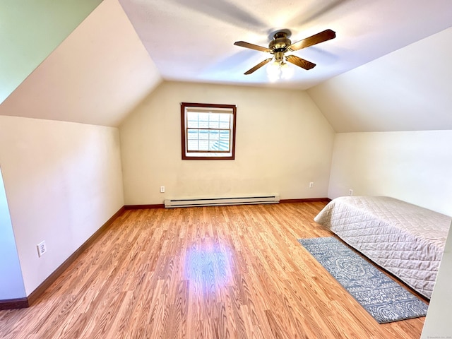 bedroom with baseboards, a baseboard heating unit, wood finished floors, and vaulted ceiling