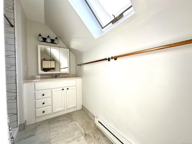 bathroom with vanity, marble finish floor, and vaulted ceiling with skylight