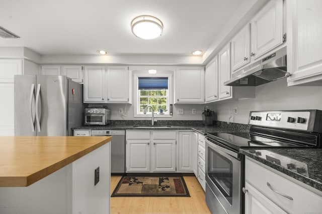3 Eastwood Dr, Granby, CT 06060 - kitchen featuring appliances with stainless steel finishes, under cabinet range hood, a sink, light wood finished floors, and white cabinets