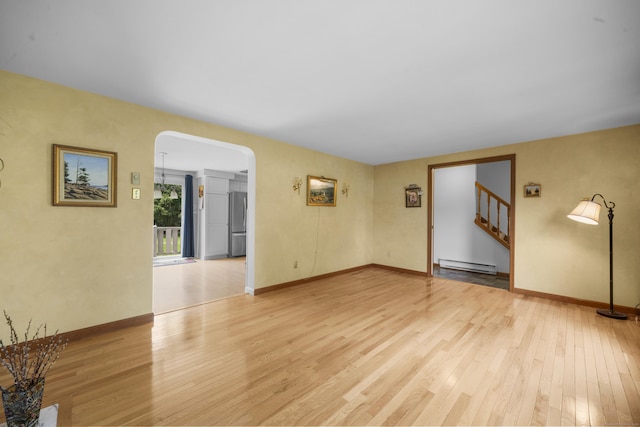 3 Eastwood Dr, Granby, CT 06060 - unfurnished living room featuring a baseboard radiator, arched walkways, light wood-style flooring, and stairway