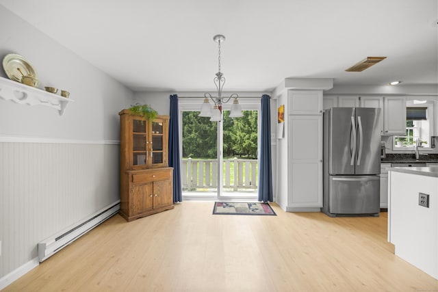 3 Eastwood Dr, Granby, CT 06060 - kitchen with freestanding refrigerator, a baseboard heating unit, light wood-type flooring, dark countertops, and a sink