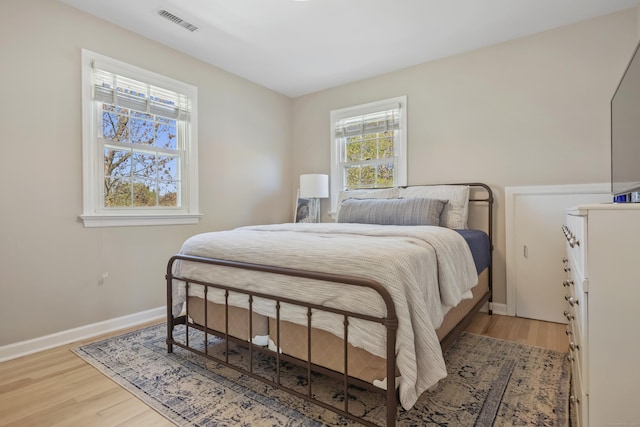 bedroom featuring visible vents, baseboards, and wood finished floors