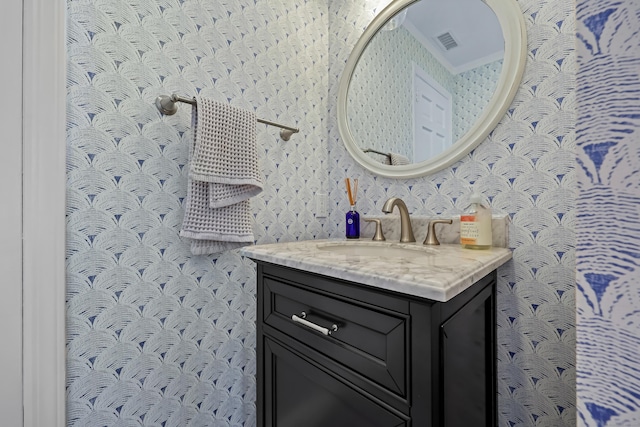 bathroom featuring visible vents, vanity, and wallpapered walls