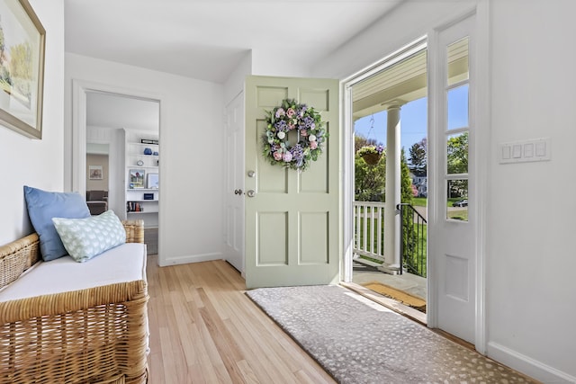 foyer with baseboards and light wood-type flooring