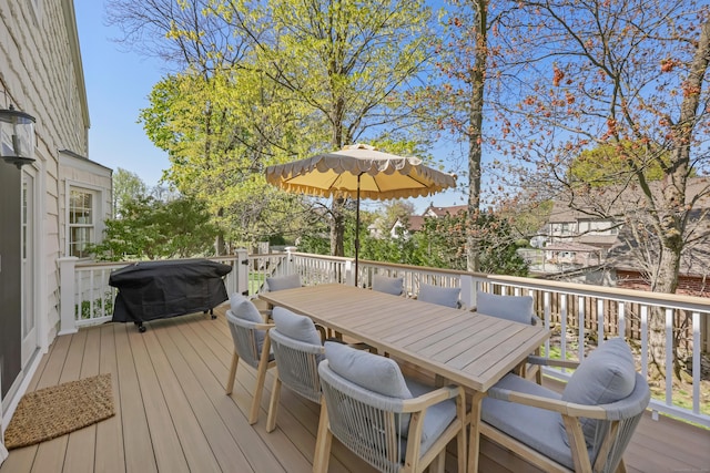 wooden terrace with outdoor dining area and grilling area
