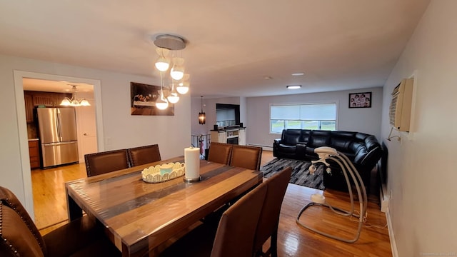 283 Hillcrest Ave, Newington, CT 06111 - dining room featuring a baseboard heating unit, light wood-type flooring, and a chandelier