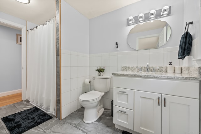 283 Hillcrest Ave, Newington, CT 06111 - bathroom featuring vanity, marble look tile flooring, toilet, curtained shower, and wainscoting