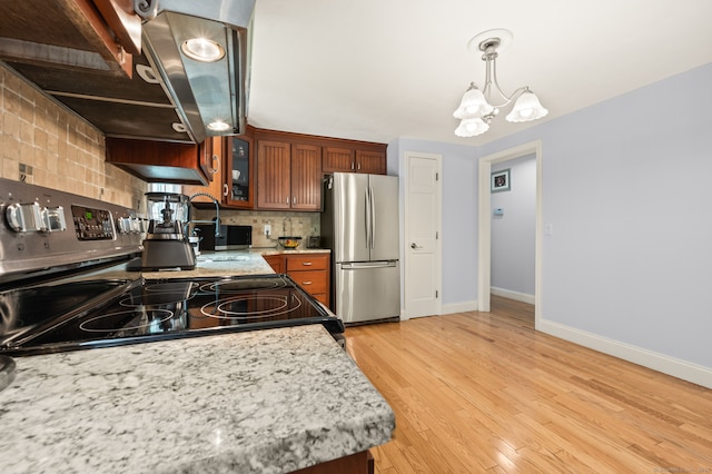 283 Hillcrest Ave, Newington, CT 06111 - kitchen with freestanding refrigerator, ventilation hood, a chandelier, baseboards, and backsplash