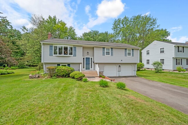 283 Hillcrest Ave, Newington, CT 06111 - raised ranch featuring a garage, a chimney, driveway, and a front lawn