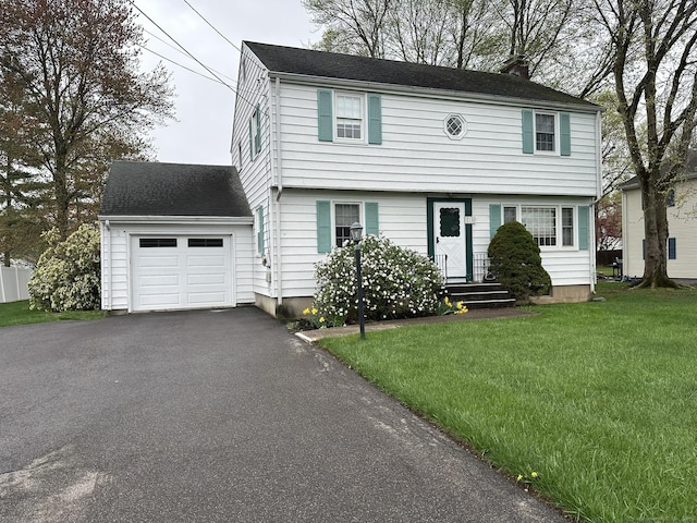 colonial home featuring a chimney, a front lawn, and aphalt driveway