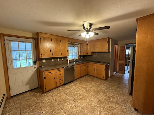 kitchen featuring dark countertops, appliances with stainless steel finishes, a ceiling fan, a baseboard radiator, and backsplash