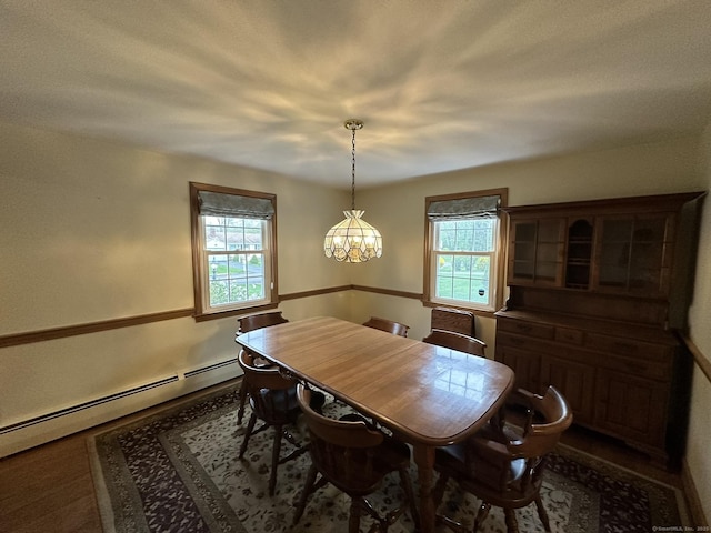 dining area featuring a baseboard heating unit and a notable chandelier