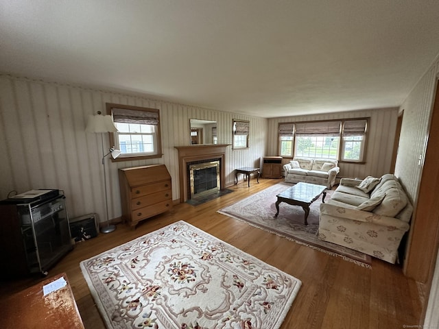 living area with a fireplace with flush hearth and wood finished floors