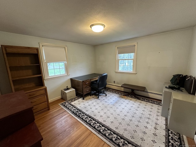office area featuring baseboards, a wealth of natural light, and wood finished floors