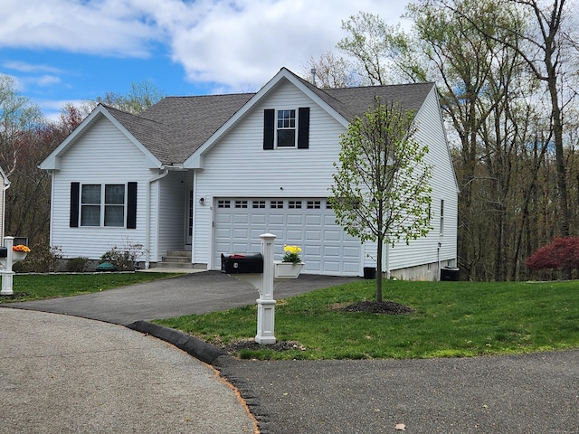 view of front of property with roof with shingles, a garage, a front lawn, and aphalt driveway