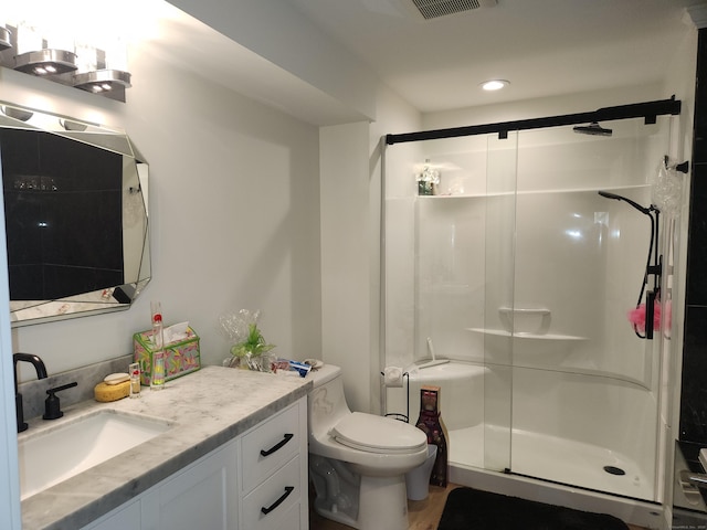 bathroom featuring vanity, toilet, and a stall shower