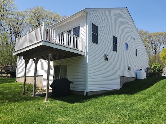 view of side of home featuring a lawn and a deck
