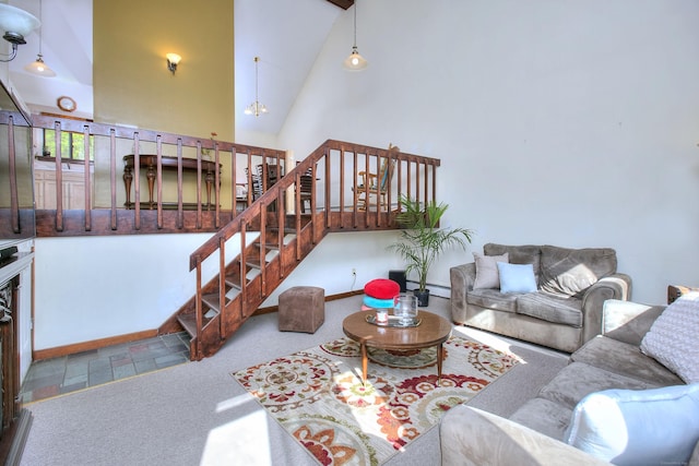 carpeted living area featuring high vaulted ceiling, baseboards, baseboard heating, and stairs
