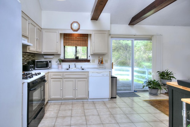 kitchen featuring beam ceiling, white dishwasher, stainless steel microwave, under cabinet range hood, and gas stove