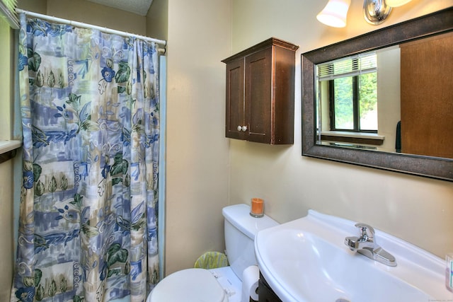 full bath featuring a sink, toilet, and a shower with shower curtain