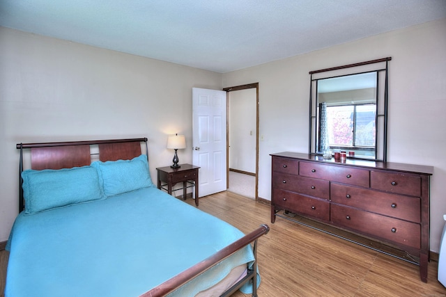 bedroom featuring baseboards and light wood-type flooring