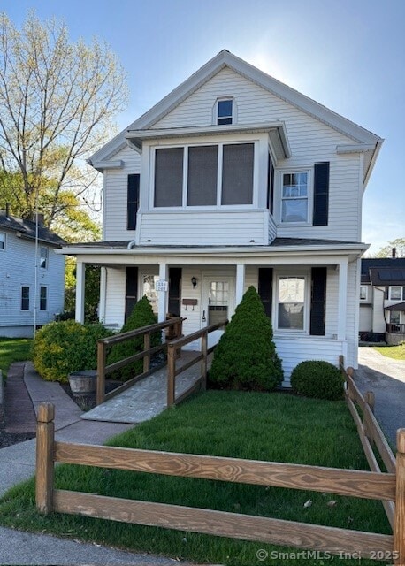 view of front of property with fence and a front lawn
