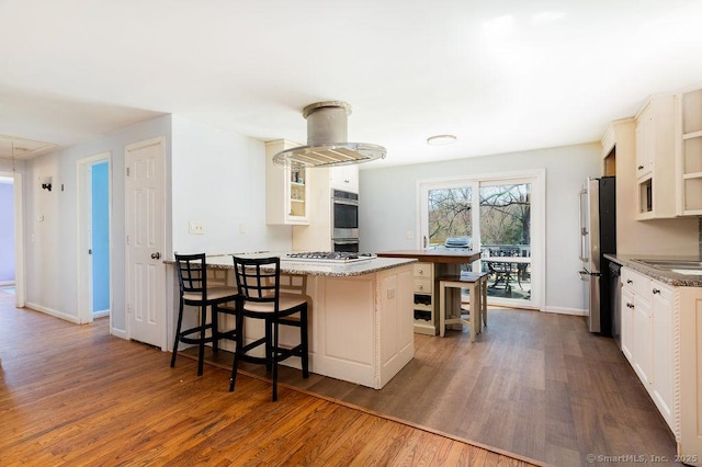 38 Black Bridge Rd, Newtown, CT 06482 - kitchen with a kitchen bar, appliances with stainless steel finishes, baseboards, a peninsula, and dark wood-type flooring