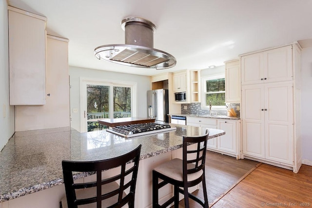 38 Black Bridge Rd, Newtown, CT 06482 - kitchen featuring a kitchen breakfast bar, appliances with stainless steel finishes, open shelves, a sink, and a peninsula